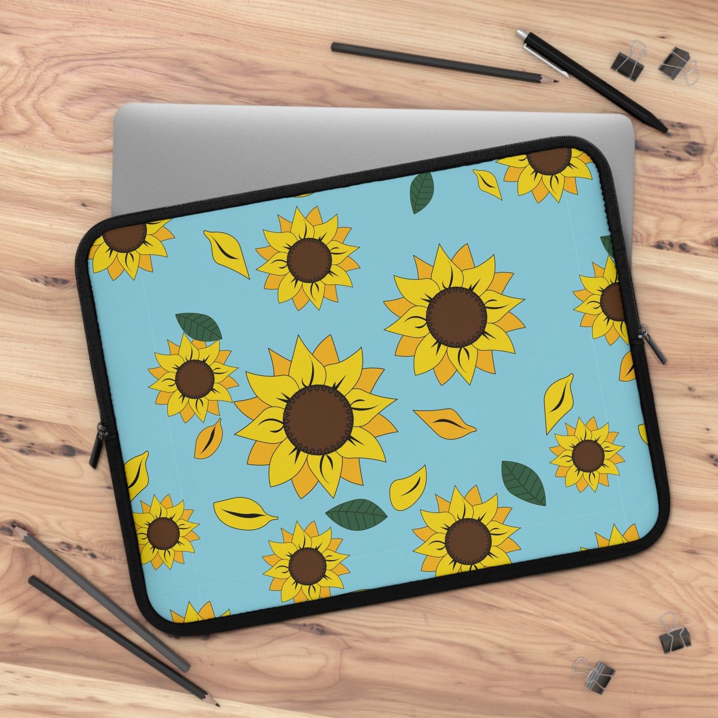 Sunflower patterned laptop sleeve laying over laptop